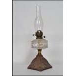 An early 20th-century duplex oil lamp having a flute raised above a faceted reservoir on top of a