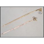 Two late 19th century / early 20th century hat pins to include a 9ct pin with seed pearl adorned