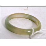 A Chinese pale Celadon to green jade bangle being  unsigned in a  good condition