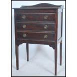 An Edwardian mahogany pedestal music cabinet having a series of fall front drawers with a gallery