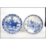 Two 20th century Delft ceramic wall hanging charger plates each having a central tondo depicting