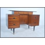 A 1970's retro teak wood G-Plan type writing table desk having floating pedestal drawers with