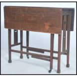 An early 20th century Arts & Crafts solid  oak gate leg table raised on splayed feet with tulip