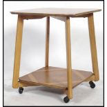 A 1930's Art Deco walnut qtr veneer lamp table having angular supports with twin tiers being qtr