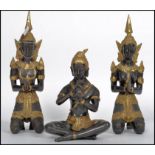 A trio of cold painted ebonised and gilded hindu deity's, 2 in the lotus position, one with