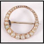 A 9ct gold and seed pearl adorned ladies vintage brooch of roundel form with graduating seed