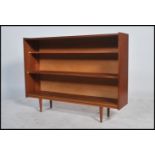 A 1970's retro teak wood open window bookcase cabinet with tapering legs to the base, shelves to