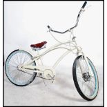 A vintage 20th century fixed speed beech cruiser bike, having an over sized low saddle, sweeping