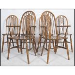 A set of 4 20th century wheelback dining chairs raised on turned legs united by stretchers over