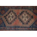 A 20th century Persian rug of Islamic form having twin medallions to centre with geometric red and