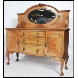 A large 1930's solid oak sideboard comprising a series of cupboards and short drawers with stage