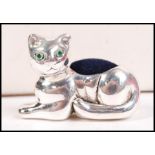 A silver pin cushion in the form of a seated cat h