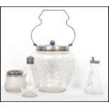 A group of silver topped and plated cut glass items to include a biscuit barrel with swing handle