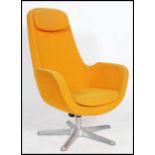 An egg chair style swivel chair having an atomic space age form in yellow raised on a metal star