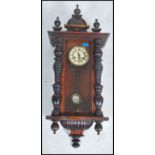 A 19th century walnut cased vienna regulator wall clock with decorative case drop pendulum and