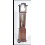 A Tempus Fugit grandmother clock with mahogany case and hood having inset brass and silvered dial