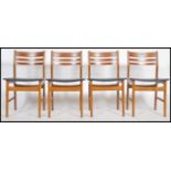 A set of 4 Danish ladder back dining chairs with black leather seat pads and teak frames with stamps