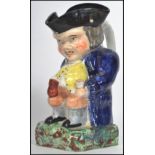 A 19th century Staffordshire Ralph Wood-type Toby jug in the form of a seated Toby Philpot holding a
