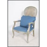 A 20th Century French carved framed Fauteuil bergere chair, having a contemporary silver painted