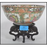 An early 20th century Cantonese rose medallion bowl with cartouche panels depicting domestic scenes,