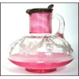 An early 19th century Georgian cranberry glass  claret ewer jug having a silver hallmarked lid.