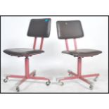 A pair of swivel chairs in red vinyl on four star