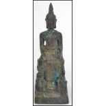 A 19th century Oriental bronze Buddha in the lotus position raised on a pedestal base with rearing