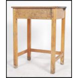 A mid 20th century beech wood school desk with lift-up lid, supported on square legs. Measures 76cms