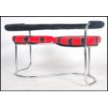 A 20th Century 'S' shaped love seat of tubular chrome construction a black padded back bar /