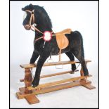 A vintage child's rocking horse of larger proportions raised on a wooden rocker with leather saddle,