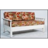 A vintage 1960's painted metamorphic day bed, slated back open arms with original seat covers.