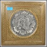 A 20th century silver white metal tondo panel depicting musicians and dancers set in a square gilt
