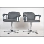 A pair of retro 20th century salon swivel armchairs having black seat and adjustable back rests