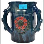 An Elton ware three handled loving jug having tube lined flowers in strawberry colourway with a blue