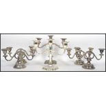 A matching set of four silver plated two arm candelabras / candlesticks raised on stepped circular