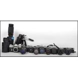 A collection of vintage cameras, lenses and equipment to include Cannon, Minolta, Olympus, Zenit