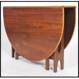 A 1970's teak wood drop leaf dining table having shaped legs in the manner of G-plan, the long