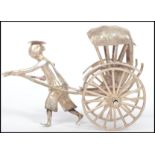 An early 20th century Chinese Export silver model of a man pulling a rickshaw, stamped 205 and