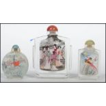 A group of three Chinese glass scent bottles each with applied decorated panels of court scenes