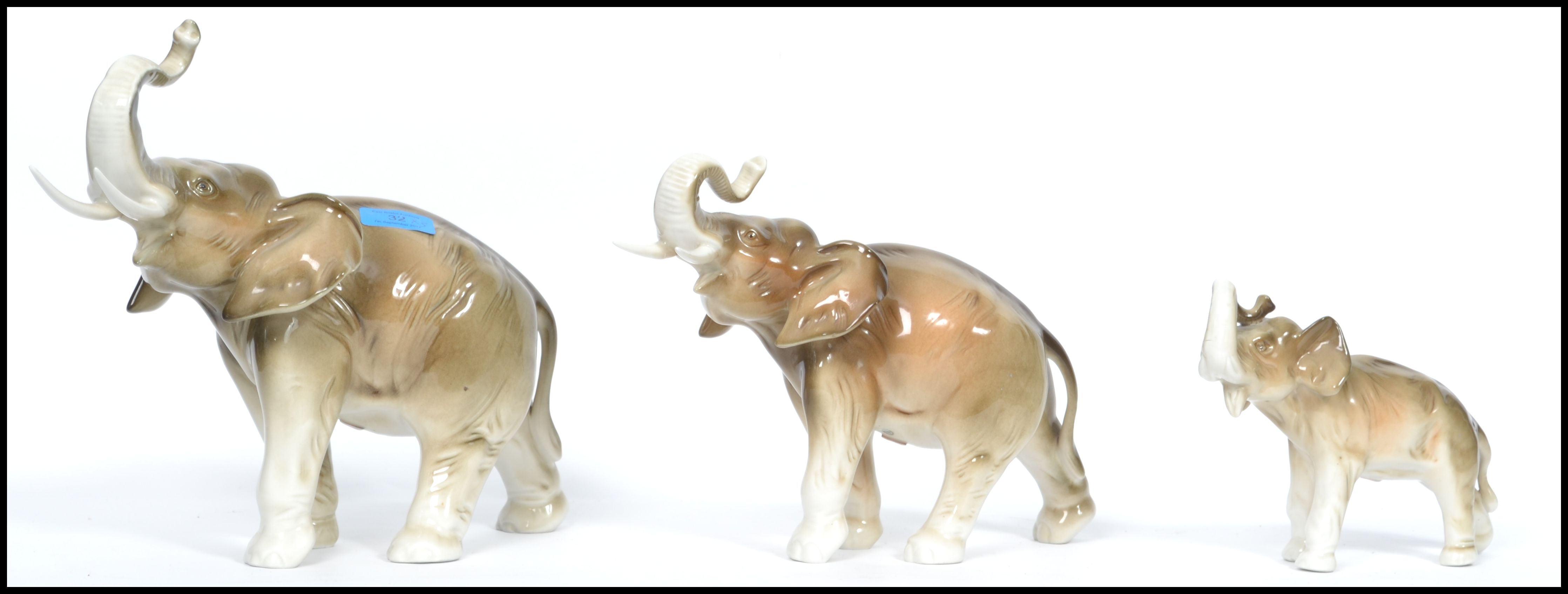 A graduating set of three Royal Dux ceramic elephants with applied pink lozenges to base. The