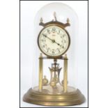 A vintage 20th century glass domed brass anniversary clock raised on a stepped circular base with