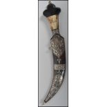 A Middle Eastern curved Jambiya dagger having a decorative silver inlaid blade with ebony and bone