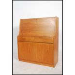 A 1970's teak wood bureau having a drop down door