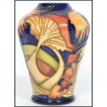 A Moorcroft baluster vase tube lined and painted in the Parasol Dance pattern on a deep blue ground.