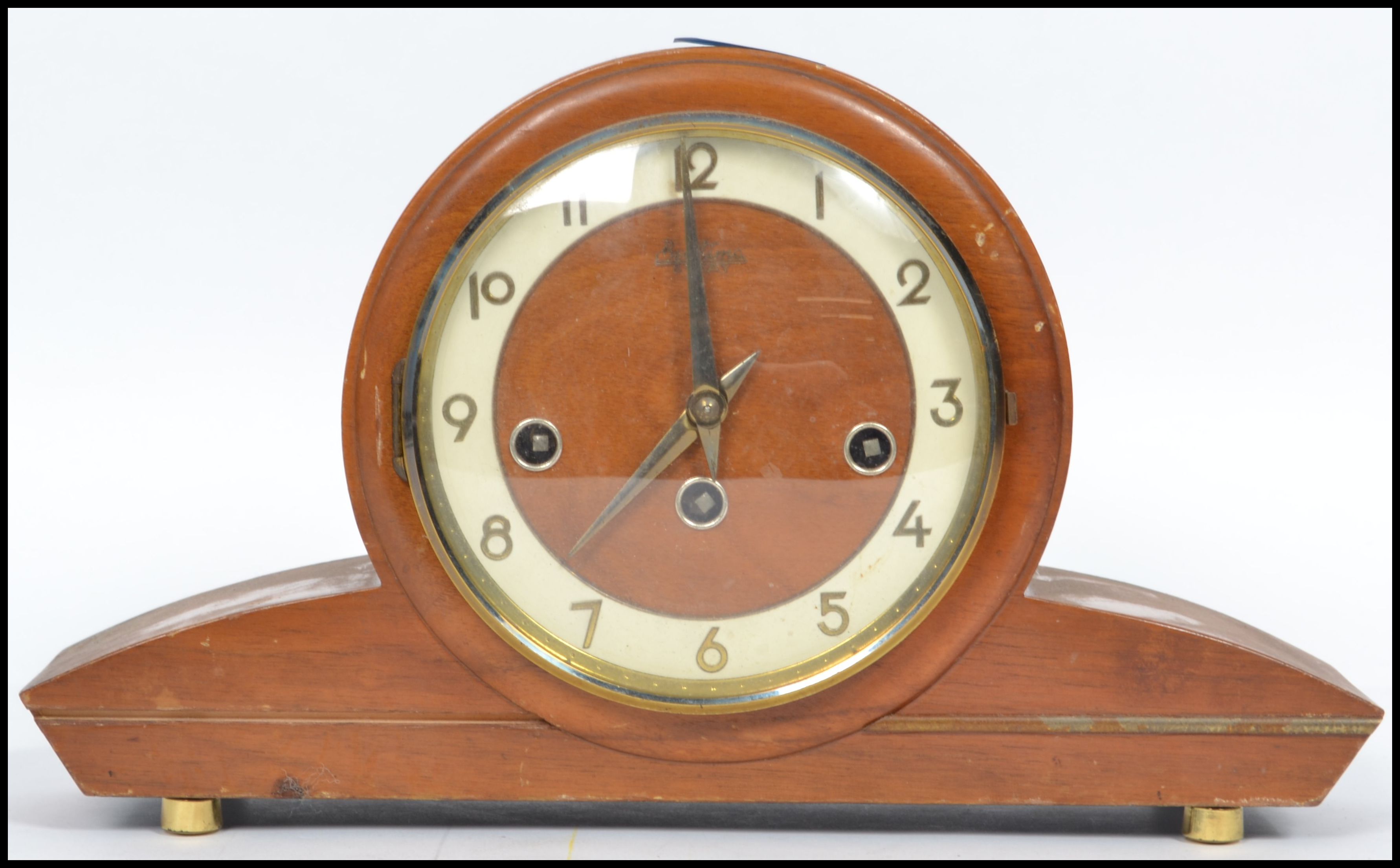 A vintage art deco style wooden cased mantle clock by Bentima having an circular face with sloped