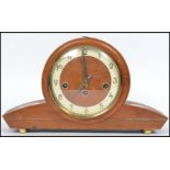 A vintage art deco style wooden cased mantle clock by Bentima having an circular face with sloped