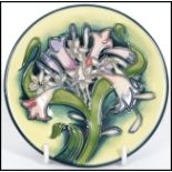 A Moorcroft ceramic tube lined coaster pin dish decorated in The Isis pattern . Condition Report: In