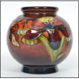 A mid century Walter Moorcroft globular ceramic vase painted and tube lined with flowers. The