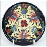 A Moorcroft ceramic tube lined coaster pin dish decorated in the Burley Butterfly pattern complete