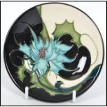 A Moorcroft ceramic tube lined coaster pin dish decorated in the Sea Holly pattern complete in the